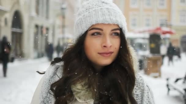 Aantrekkelijke mooie dame lopen over besneeuwde stad achtergrond — Stockvideo