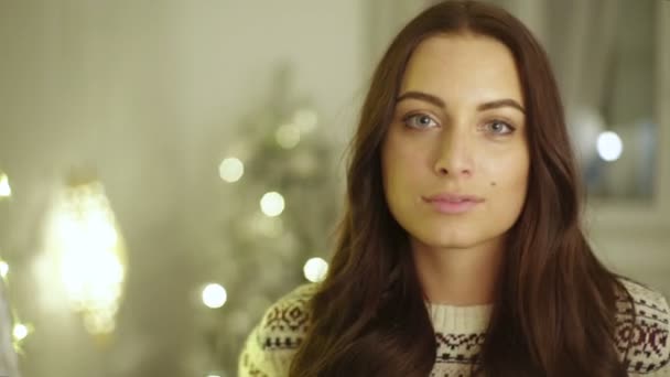 クリスマスの時期にカメラにポーズをとって若い笑顔の女性. — ストック動画