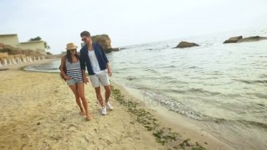 Genç çekici kadın ve güzel kum Sahilde yürüyüş yakışıklı erkek.