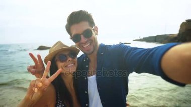 Mutlu gülümseyen kadın ve onun erkek arkadaşı selfies sahilde alarak yakın çekim.