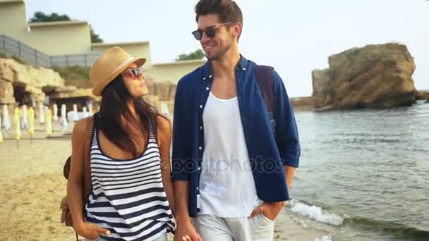 Dos jóvenes felices caminando por la playa y disfrutando de un buen día de verano . — Vídeos de Stock