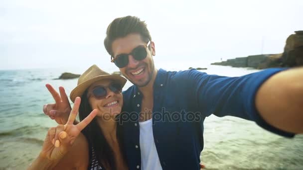 Mutlu gülümseyen kadın ve onun erkek arkadaşı selfies sahilde alarak yakın çekim. — Stok video