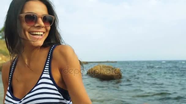 Nahaufnahme einer jungen sexy Dame, die ihren Mann hält und am schönen Strand spaziert. — Stockvideo