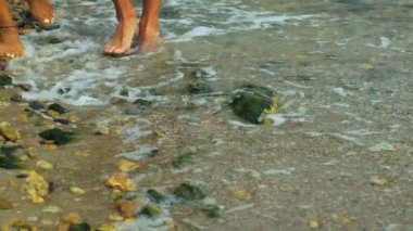 İki kişinin bacağını üzerinde bilezik giyen kadın taşlı Sahilde yürüyüş yakın çekim.