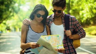 İki genç insanlar üzerinde yeşil park rahatlatıcı ve onların yolculuk için yeni planı yapma.