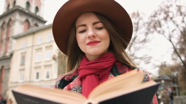 Menina bonita nova no livro de leitura de chapéu no parque da cidade. Movimento lento . — Vídeo de Stock