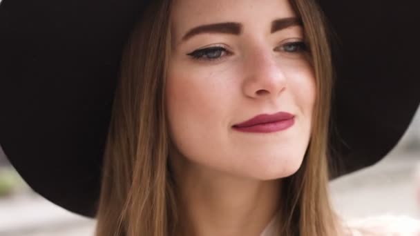 Девушка сидит в кафе на открытом воздухе и улучшает свой макияж — стоковое видео