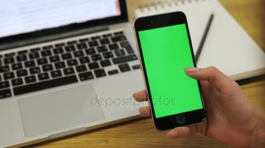 Dikey smartphone ile yeşil ekran kullanan kadın. Yakın çekim shot cep telefonunuzu kaydırma kadının elleri. Chroma anahtar.