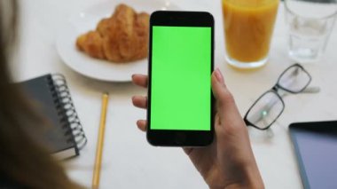 Smartphone ile yeşil ekran kullanan kadın. Yakın çekim video cep telefonu holding womans eller. Chroma anahtar. Dikey