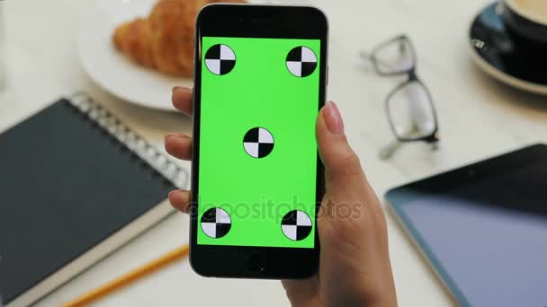 Close-up van vrouw smartphone met groen scherm in café. Close-up video van dames handen met mobiele telefoon. Chromakey. Het bijhouden van beweging. Verticaal — Stockvideo