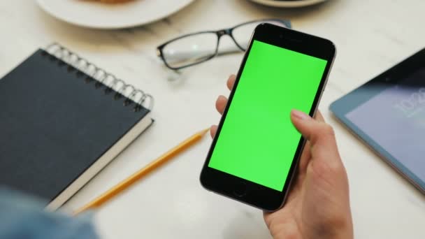 Close-up de mãos de mulher usando smartphone com tela verde. Close up vídeo de mulheres mãos rolando páginas no telefone celular. Chave Chroma. Vertical — Vídeo de Stock