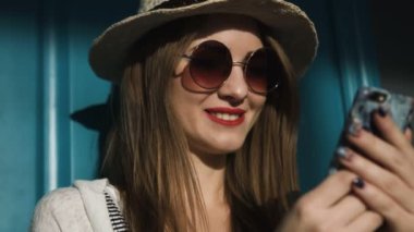 Yaz tatil seyahat tutarak ve gün batımı, Hawaii plajda akıllı telefon bakarak karışık yarış oldukça gülümseyen genç kadının. Deniz ve arka planda ufuk