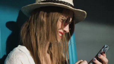 Yaz tatil seyahat tutarak ve gün batımı, Hawaii plajda akıllı telefon bakarak karışık yarış oldukça gülümseyen genç kadının. Deniz ve arka planda ufuk