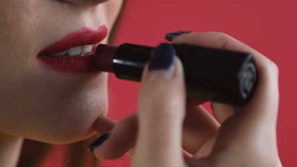 Девушка красит губы крупным планом — стоковое видео
