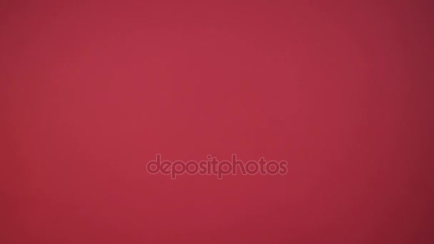 クローズ アップ肖像画上の赤い壁紙スタジオで美しい若い女性 — ストック動画