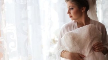 Güzel gelin Gelinlik Düğün töreni önce ve pencereden bakarak dantel üzerinde çalışıyor