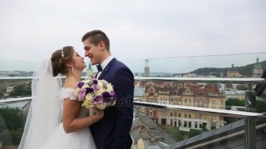 Damat ve gelin çatıda eski şehir manzarası önünde öpüşme. Lviv, Ukrayna. Güzel şehir manzaralı