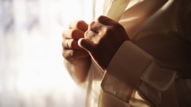 Damat Düğün töreni önce onun beyaz gömlek kadar düğmelerini. Yakın çekim. Yumuşak ışık