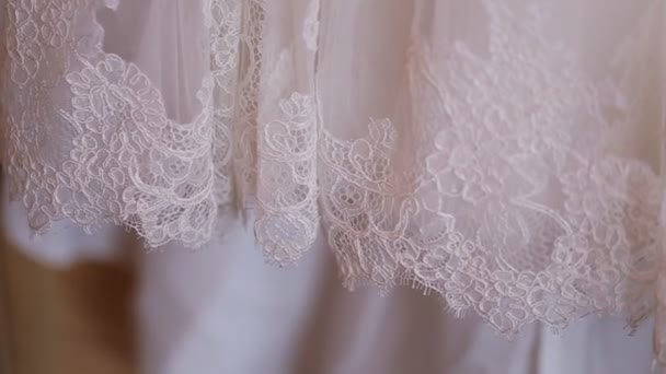 Gros plan de tissu de mariage avec dentelle. Préparation du mariage. Robe de mariée sur cintre — Video