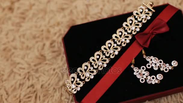 Beaux bijoux luxueux en coffret cadeau avec tissu noir. Vue rapprochée du bracelet et des boucles d'oreilles dans la boîte à bijoux — Video