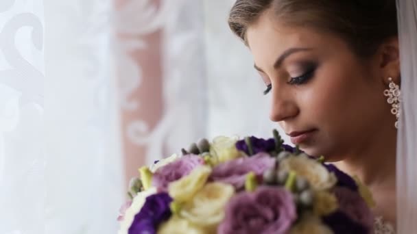 Bella sposa profumato bouquet di fiori di nozze e guardando la fotocamera. Da vicino. — Video Stock