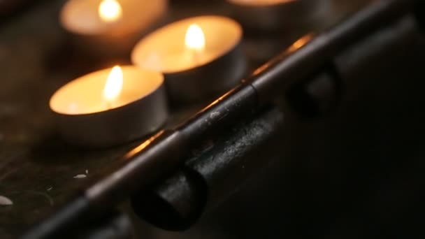 Velas na mesa na igreja dominicana. Um monte de pequenas velas com luz amarela na igreja católica. Fechar — Vídeo de Stock