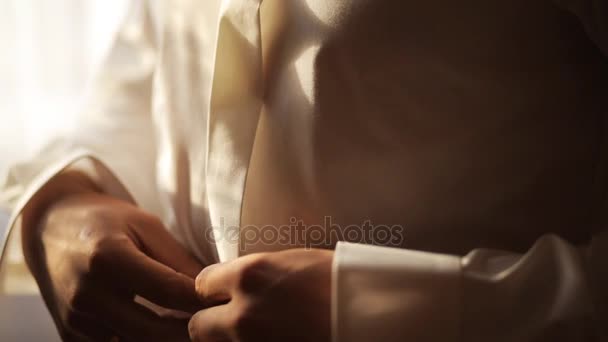 Novio abotonando su camisa blanca antes de la ceremonia de boda. De cerca. Luz suave — Vídeo de stock