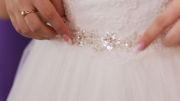Bruidsmeisjes helpen van de bruid om te kleden voordat de ceremonie van het huwelijk. Close-up van trouwjurk — Stockvideo