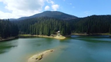 Havadan görünümü. Yukarıdan görüntüleyin. Forest yakınındaki dağ gölü manzarası. Mavi bulutlar. Göl ve yeşil alanları üzerinde uçan