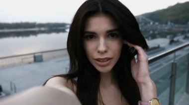 Beyaz t-shirt onun mobil kentsel bir sokakta bir selfie alarak gülümseyen kadın