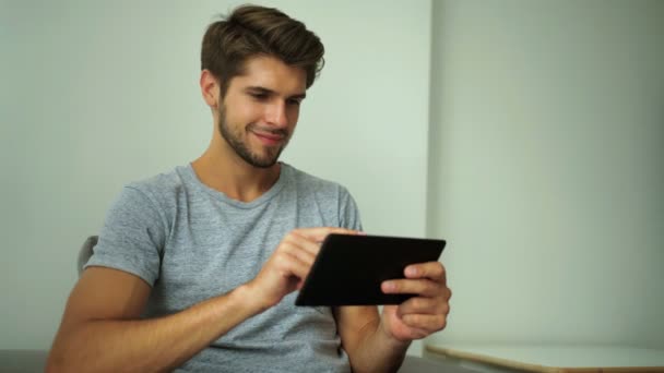 Knappe man tablet pc thuis gebruiken — Stockvideo