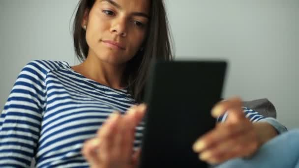 Jonge vrouw met prachtig haar, zittend met tablet in haar handen en genieten van goede zomerdag. — Stockvideo