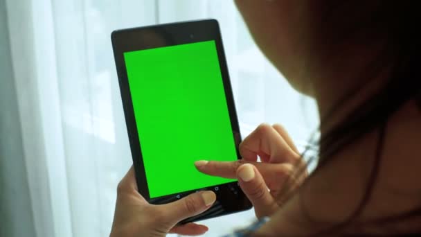Κοντινό πλάνο της μελαχρινή νεαρή γυναίκα κρατώντας tablet στα χέρια. Πράσινη οθόνη Chroma Key. Κοντινό πλάνο. — Αρχείο Βίντεο