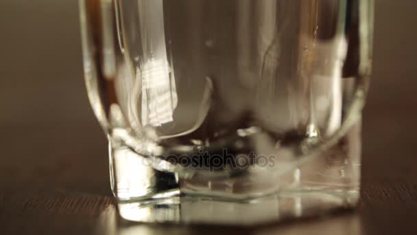 Close up shot of filling up empty glass with water. Slow motion. Bubbles go up. Close up view of glass bottom — Stock Video