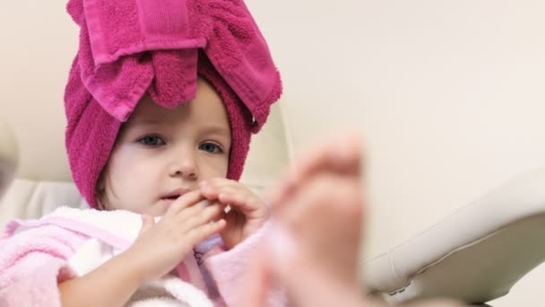 Nagelmeister macht Pediküre für hübsches kleines Mädchen im professionellen Salon. Fuß aus nächster Nähe — Stockvideo