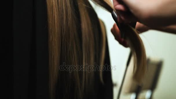 전문 스타일 리스트, 미용실 아름 다운 강한 머리 스트레이트 살롱에서 젊은 금발 소녀에 교정기를 사용 하 여 스타일 리스트. 보기 닫기. — 비디오