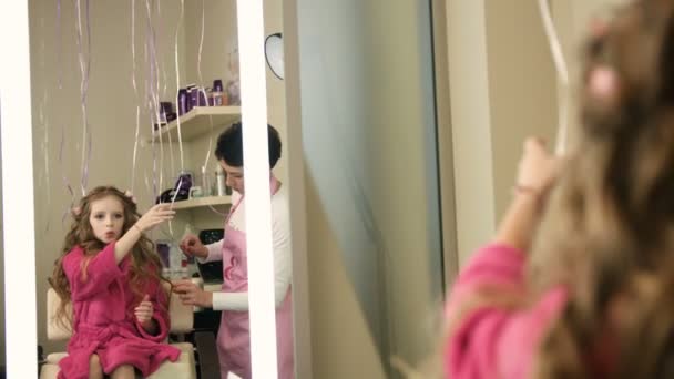 Professionele kapper, stylist kapsel doen voor mooie meisje in de beauty salon. — Stockvideo