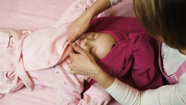 Esteticista profissional aplicando máscara e fazendo massagem no belo rosto da menina no salão de beleza. Terapia de Spa. Vista de perto — Vídeo de Stock