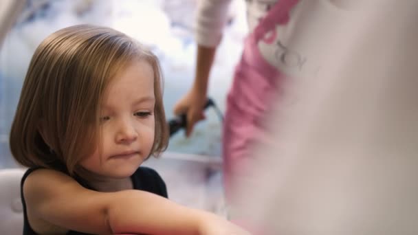 Artista de uñas haciendo manicura para niña bonita en el salón profesional. Vista de cerca del maestro de manicura aplicando gel polaco — Vídeos de Stock