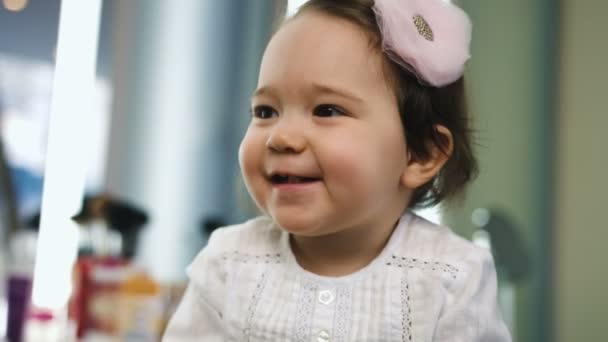 Retrato de una niña bonita sonriendo en el salón de belleza. Vista de cerca . — Vídeo de stock