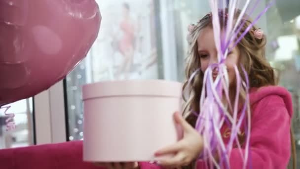 Petite fille donnant boîte cadeau avec des ballons à deux jolies filles. gros plan — Video