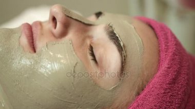 Yüz görünümü kapatın. Profesyonel master spa salonda kadının yüzünde kil uygulamak. Yüz Bakımı Güzellik salonda. Tedavi