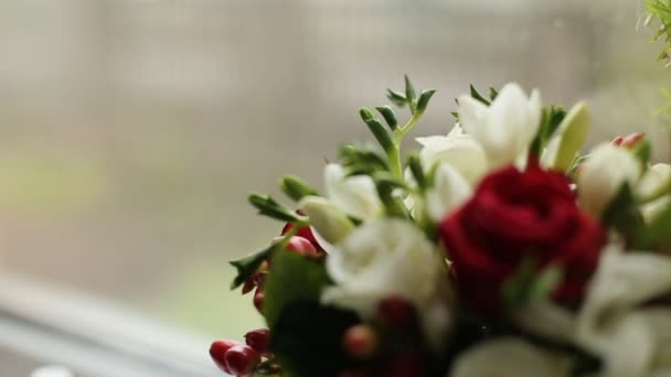 Vackert bröllop bukett med röda och vita rosor. Färsk bröllop blombukett nära fönstret. Bröllopsbutiker bröllop bukett. Nära upp skott — Stockvideo