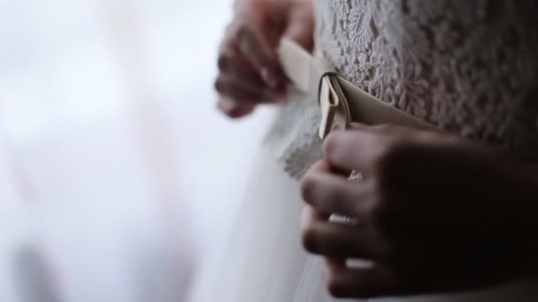 Novia preparándose para la ceremonia de boda. Primer plano hermoso vestido de novia blanco con lazo . — Vídeo de stock