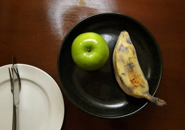 Pomme et banane dans l'assiette — Photo