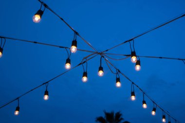 Gece mavisi gökyüzü arka planında bir ampul. festival konsepti.