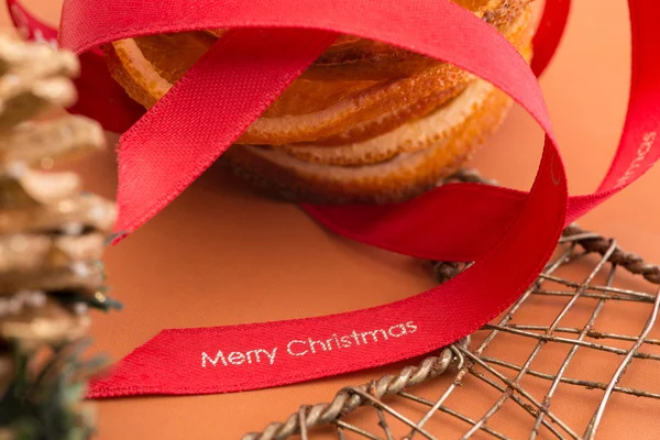 Red Christmas Ribbon Alongside Orange Slices and Wire Mesh