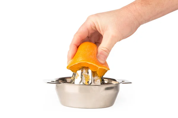 Рука витягує апельсин у соковижималку з нержавіючої сталі — стокове фото