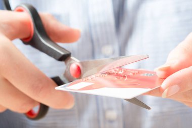 Hands Cutting Visa Card with Scissors clipart