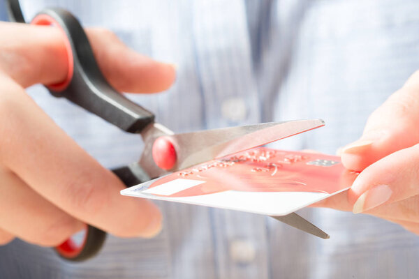 Hands Cutting Visa Card with Scissors